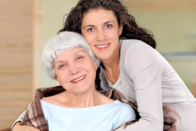 caregiver hugging senior woman